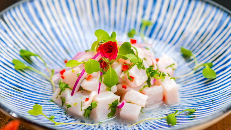 cubes of marinated fish on a blue and white plate