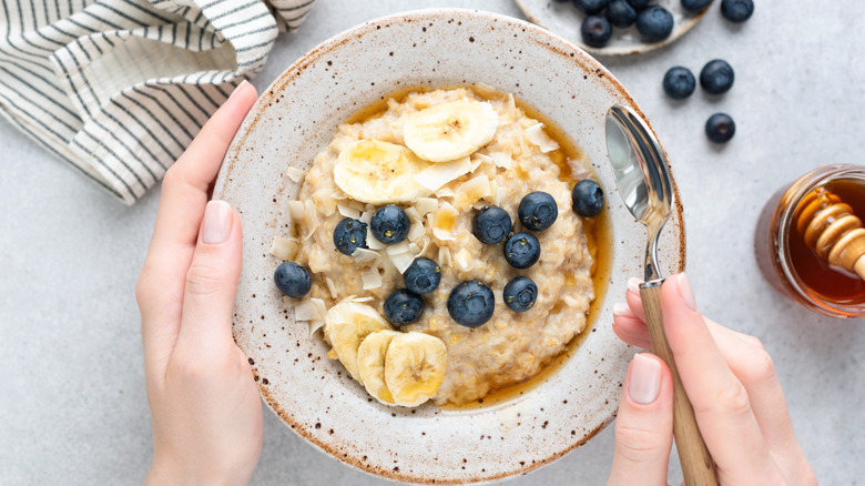 yummy oatmeal in bowl with blueberries and bananas