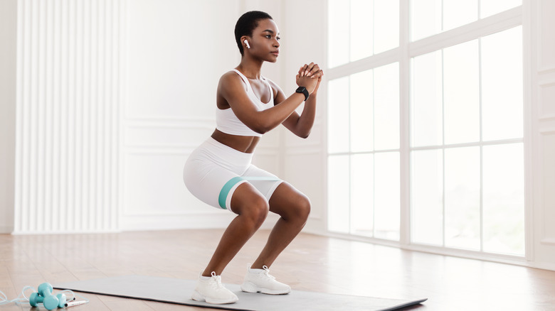Woman doing squats on mat
