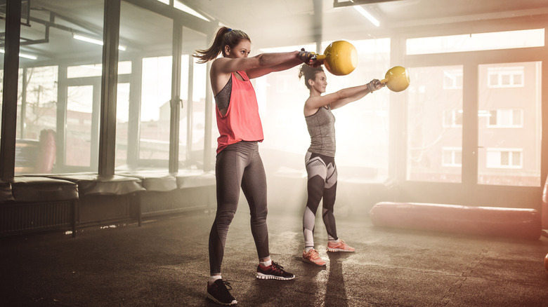 two women doing kettlebell swing