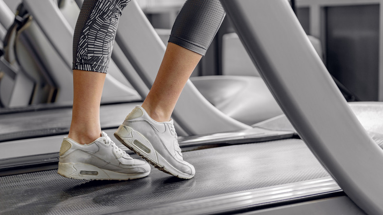 legs of a woman walking incline treadmill