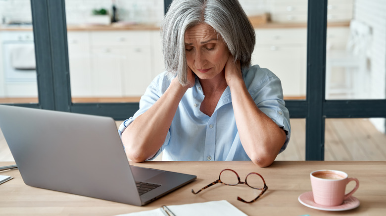 woman holding neck in pain