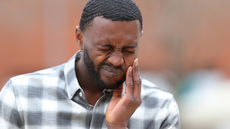 man holding jaw in pain