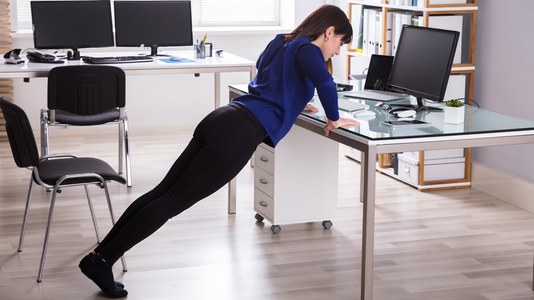 woman doing pushups on her desk