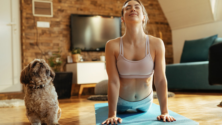 woman doing yoga with dog