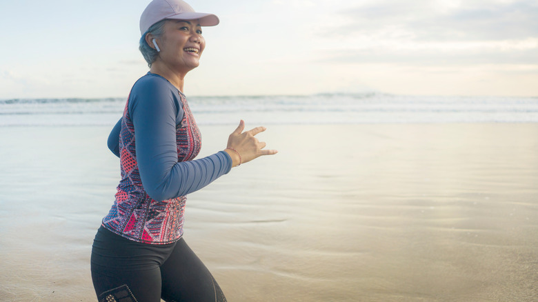 Senior woman jogging at beach