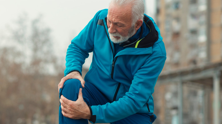 man holding knee while running