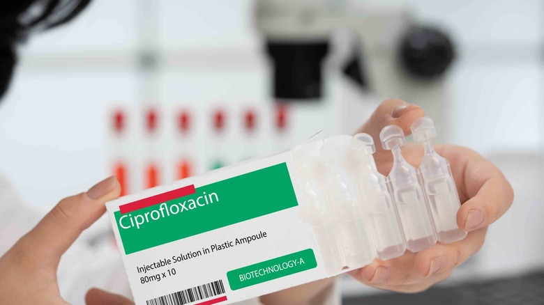 A person holding a box of ciprofloxacin antibiotics