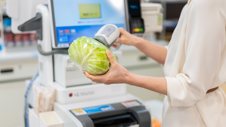 woman uses self-checkout at market 