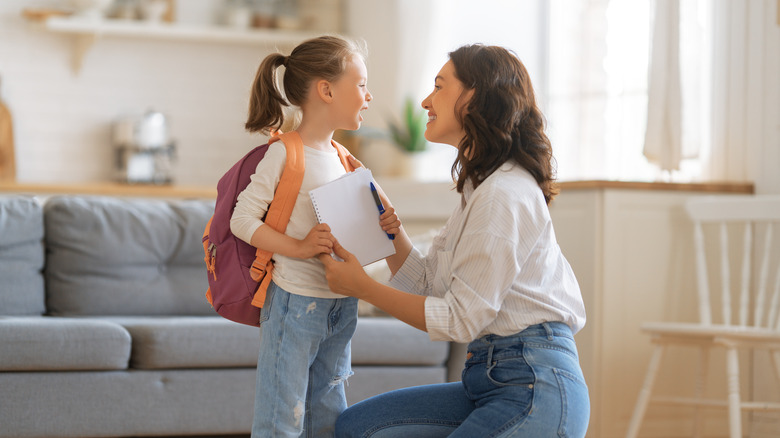 mother preparing daughter for school