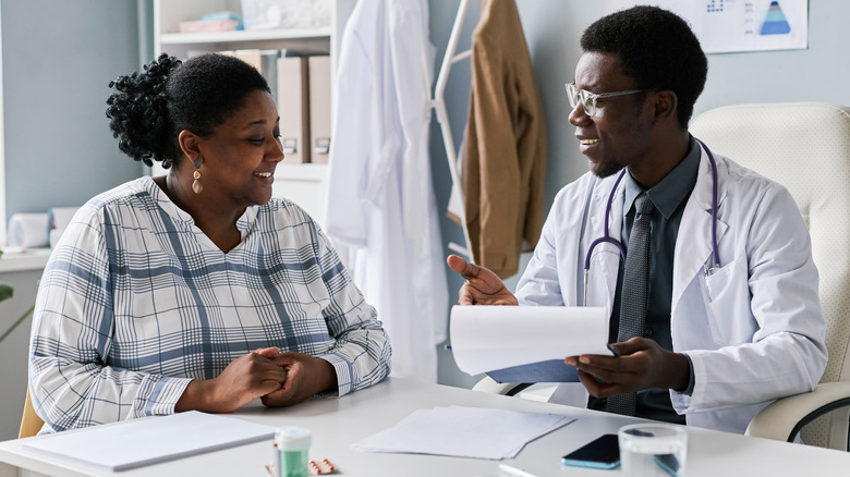 Smiling doctor speaking with patient