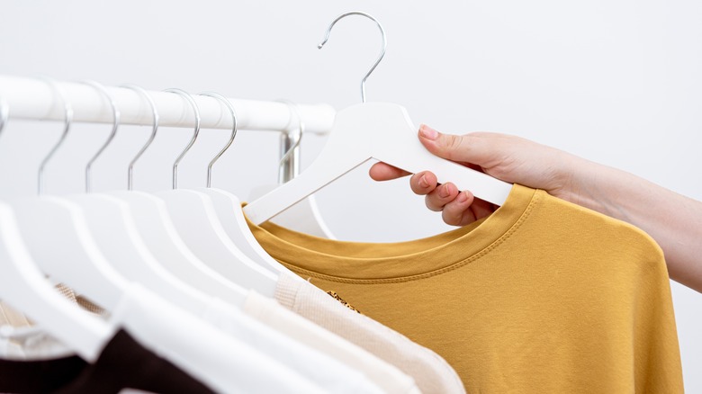 Hand picking a top from a rack