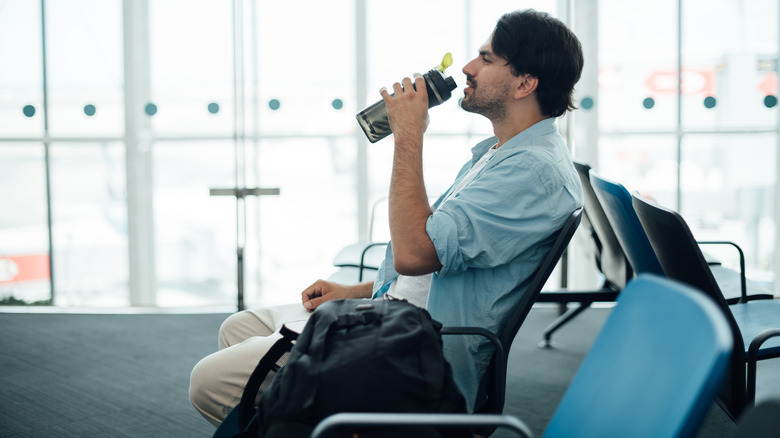 Man drinking water in airport