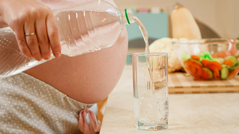 Pregnant woman pouring water 