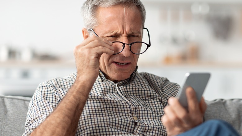 Older man peering through glasses