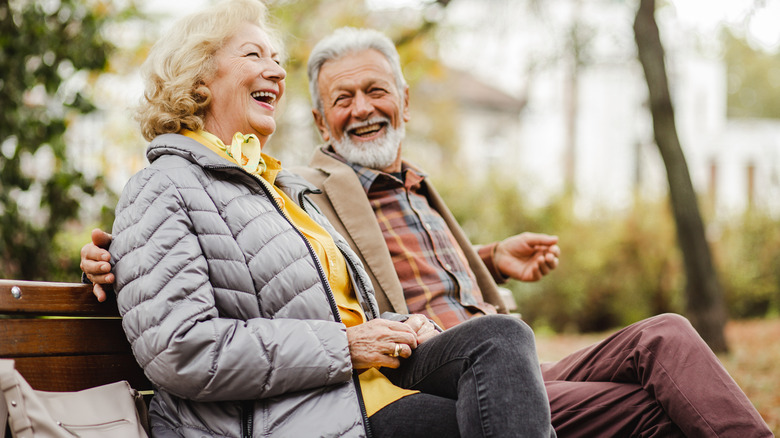 Laughing couple on park bench