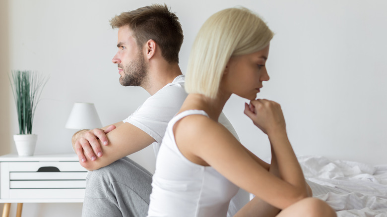 Couple in bed having issues facing away from each other