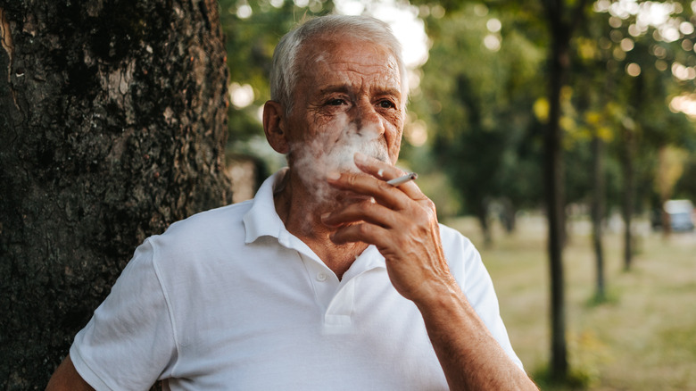 Older man smoking a cigarette outdoors