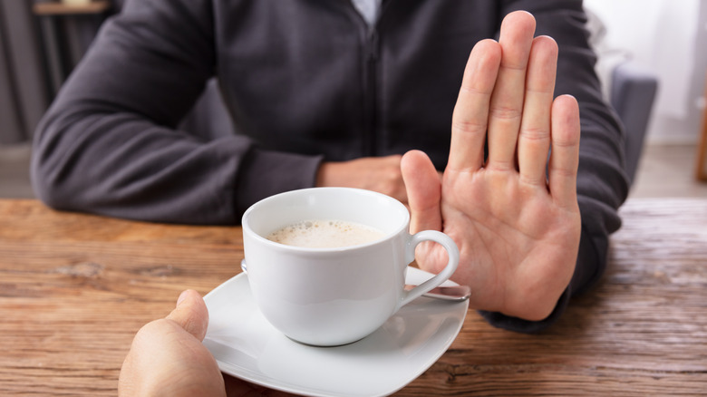hand waving off another cup of coffee