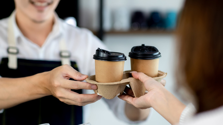 Person being served cups of coffee