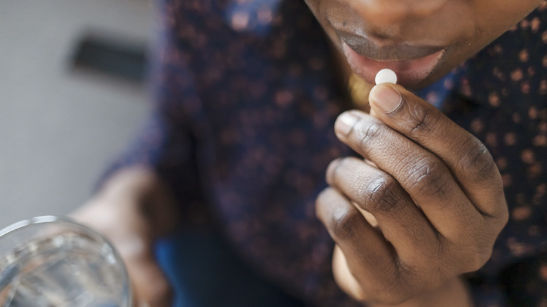 Woman taking small pill