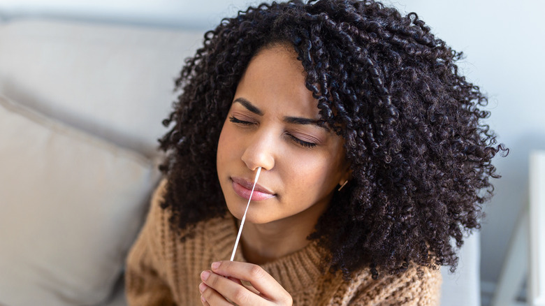 Woman self-administering at-home nasal swab