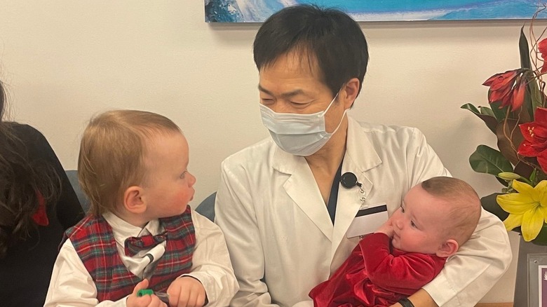 Dr. John Zhang holding two babies conceived via IVF