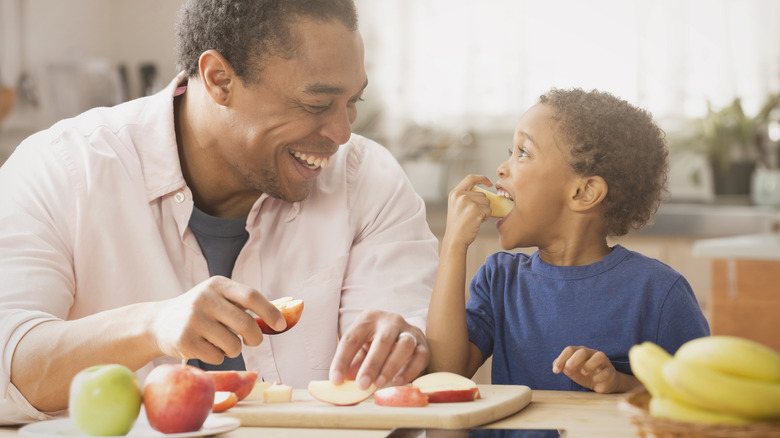 Man and young boy eating apples