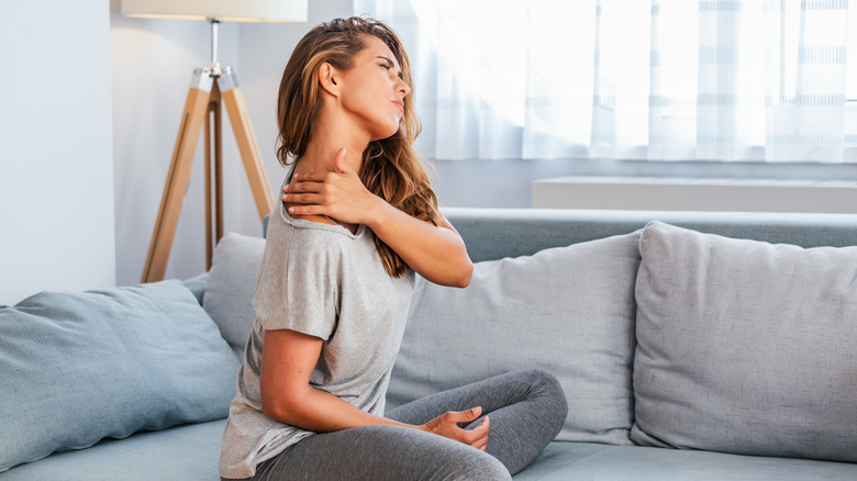 Woman holding neck in pain