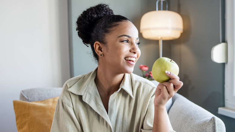 Smiling woman holding apple