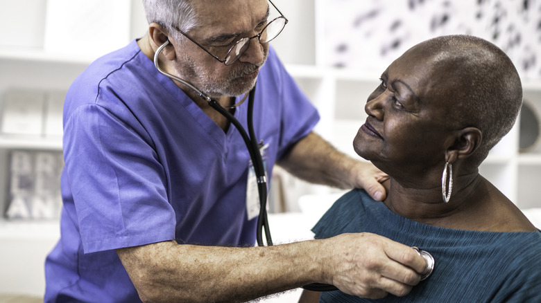 Doctor using stethoscope on patient