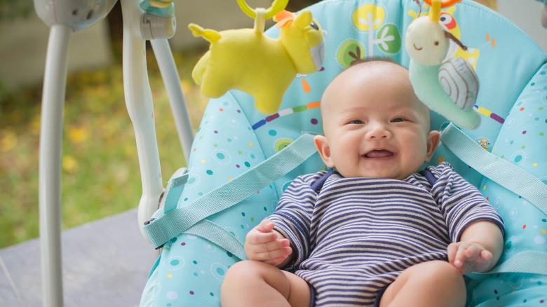 Happy baby lies in rocker