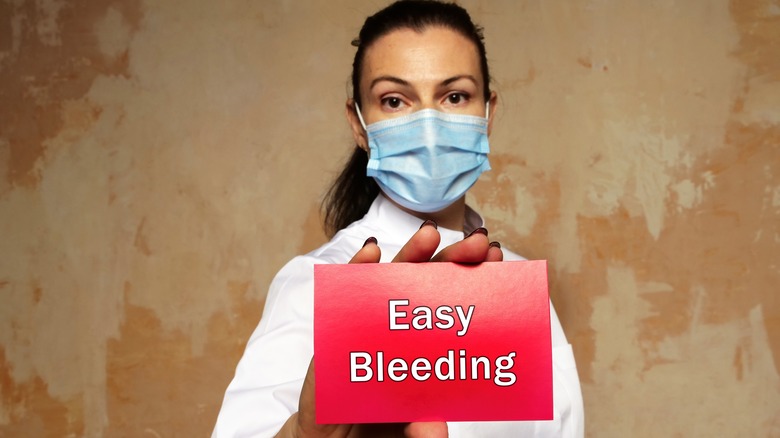 Woman holding card with message "Easy Bleeding"