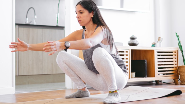 Young woman doing squat exercises