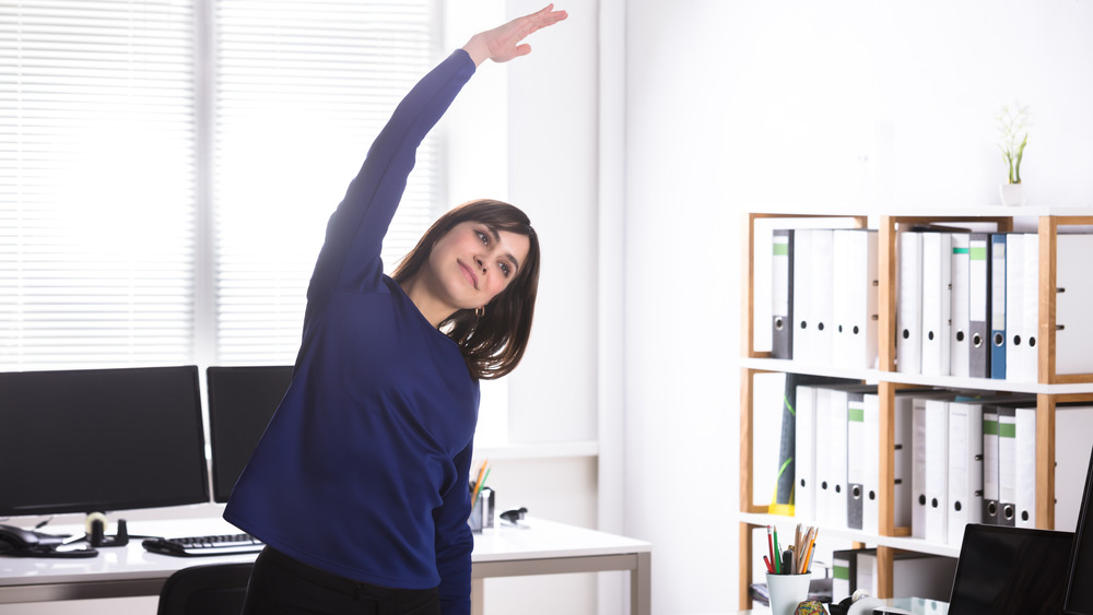 woman stretching in office