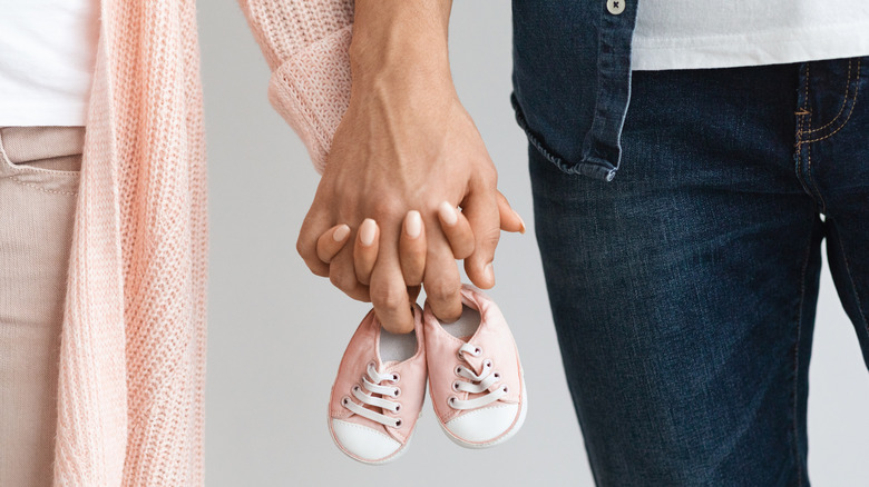 man and woman holding hands expecting baby