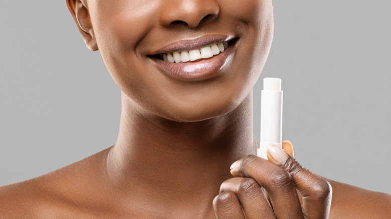 smiling woman holding a chapstick