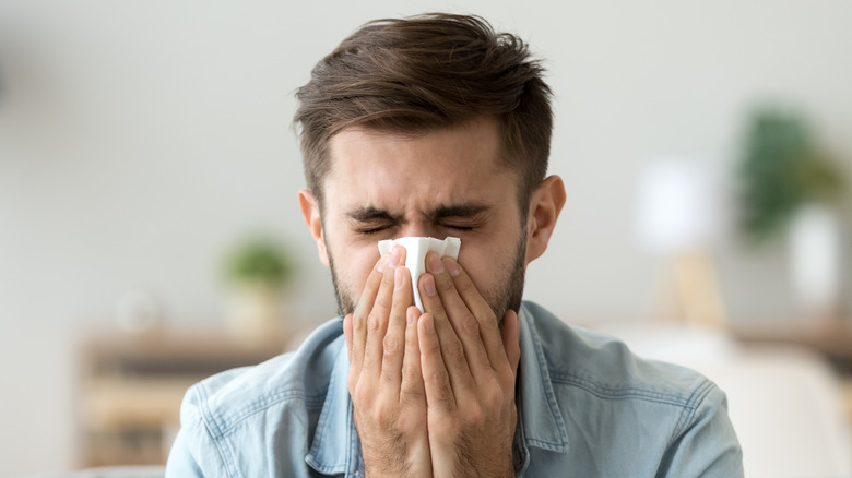 man blowing nose