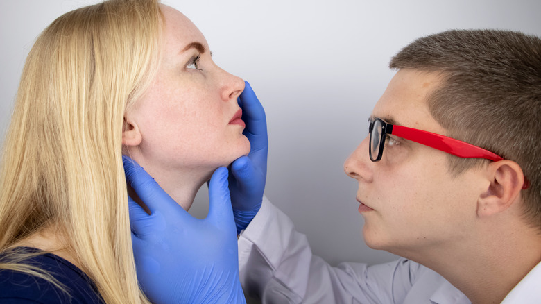 doctor examining woman's nose