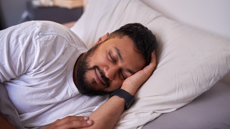 Smiling man asleep in bed