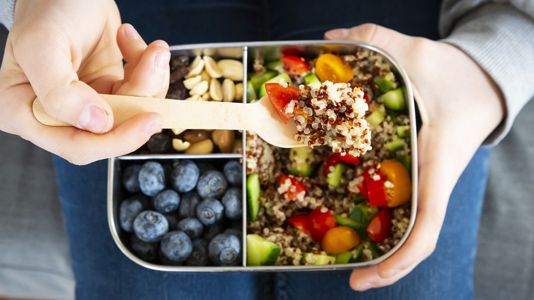 tin with quinoa, blueberries, nuts and tomatoes