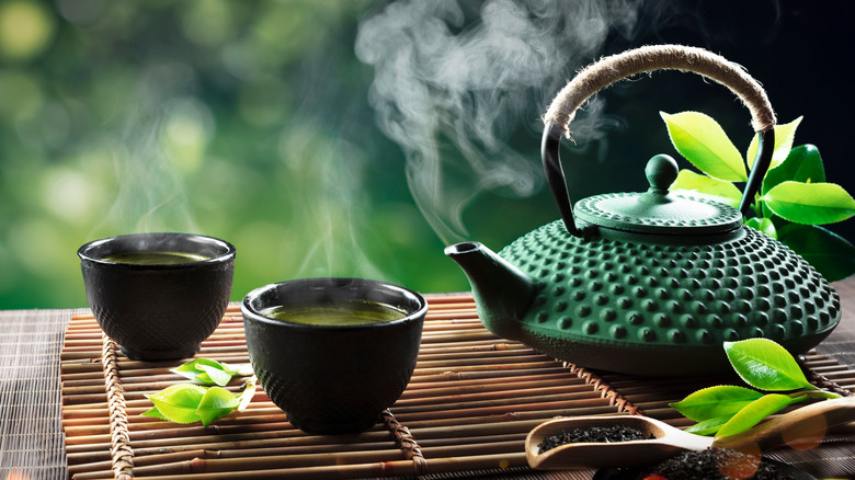 Tea pot and tea cups with hot tea