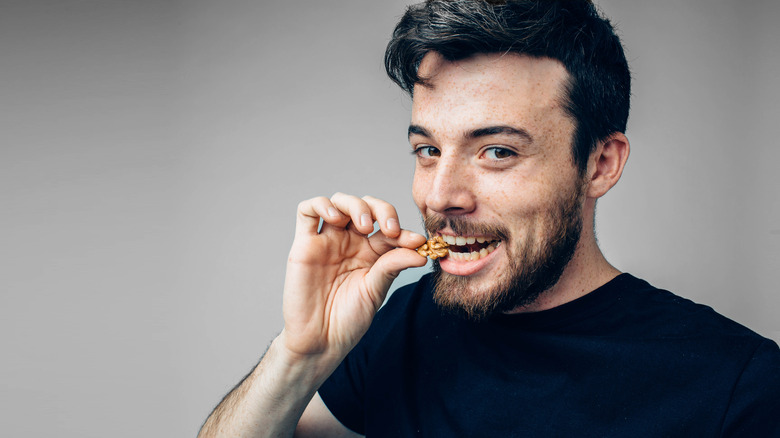 man biting walnut