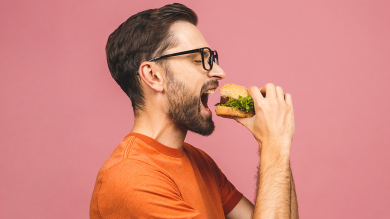 man eating hamburger