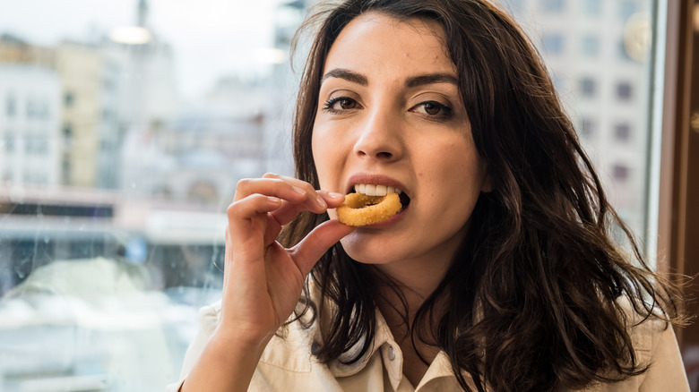 woman eating an onion ring