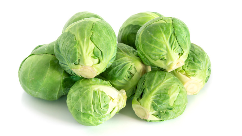 A pile of Brussels sprouts against white background