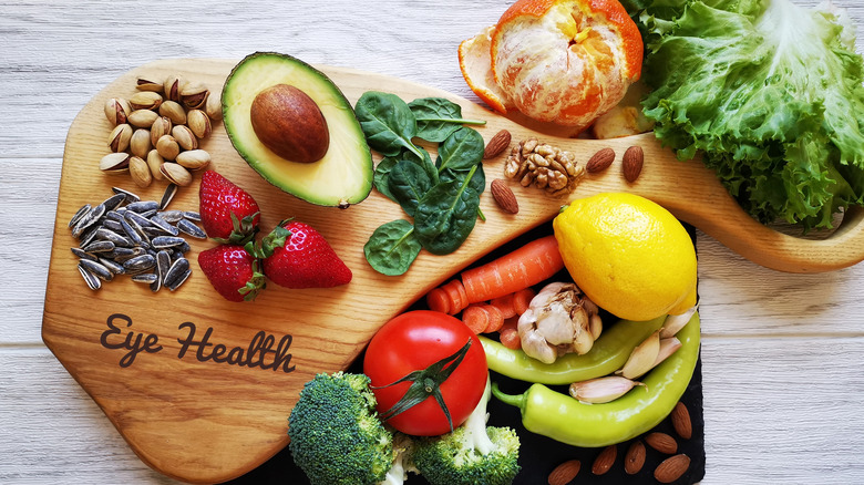 Overhead view of foods for eye health, like fruits, veggies, nuts, and seeds