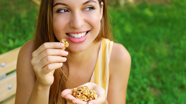 happy woman eating walnuts