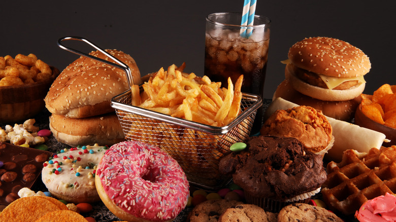 A table loaded with baked treats, fries, and burgers