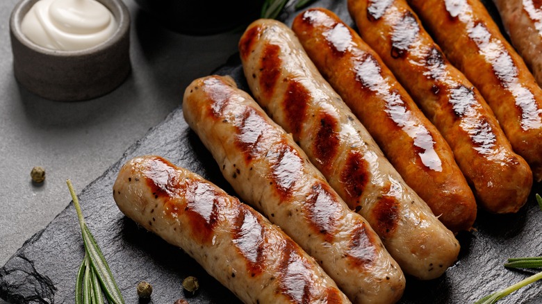 sausages on wooden slab with cream 